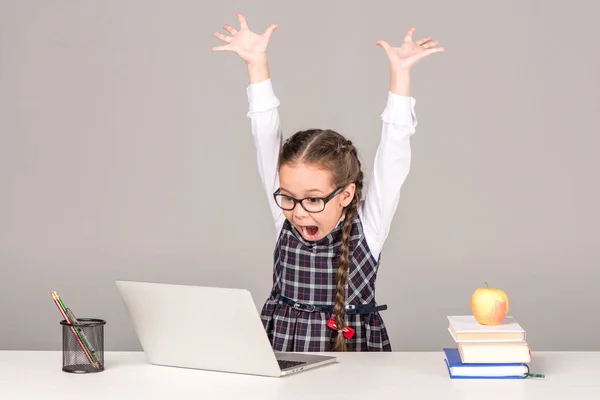 Écolière au bureau avec ordinateur portable — Photo de stock