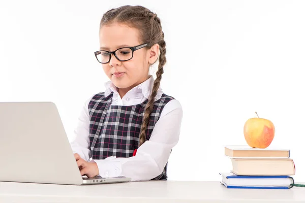 Écolière au bureau avec ordinateur portable — Photo de stock