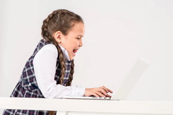 Écolière tapant sur ordinateur portable — Photo de stock