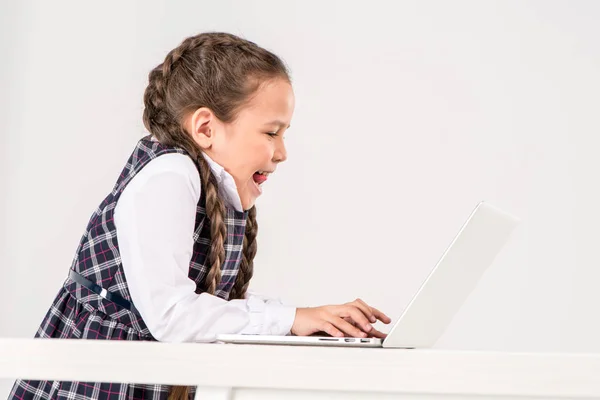 Colegiala escribiendo en el ordenador portátil — Stock Photo