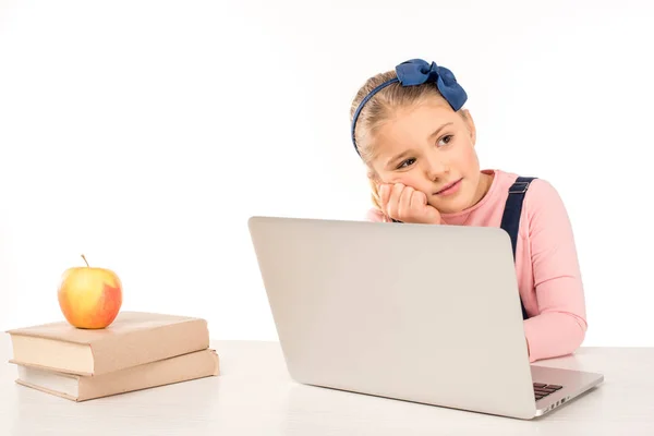 Schoolgirl at desk with laptop — Stock Photo