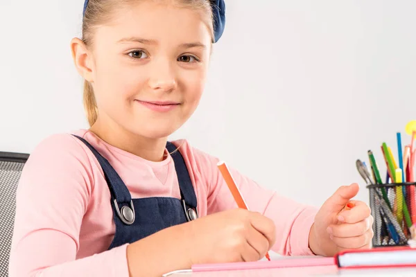 Souriant écolière faire des devoirs — Photo de stock