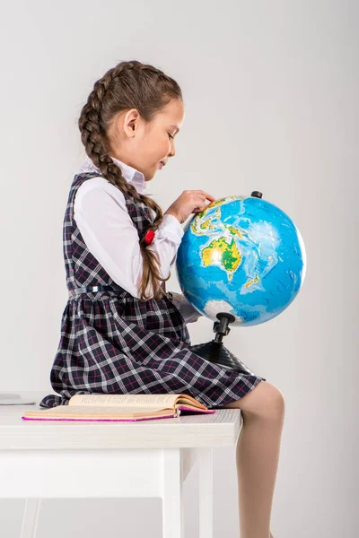 Schoolgirl exploring world on globe — Stock Photo