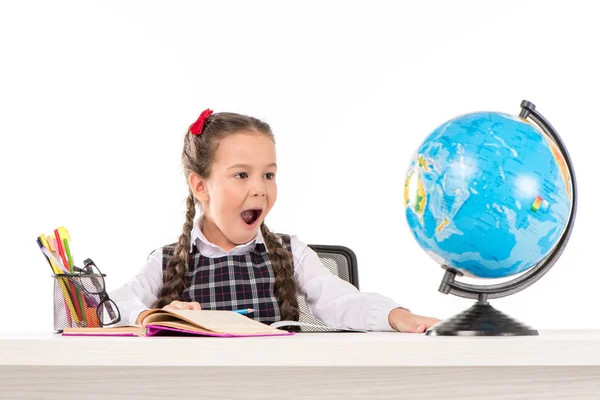 Schockiertes Schulmädchen blickt auf Globus — Stockfoto