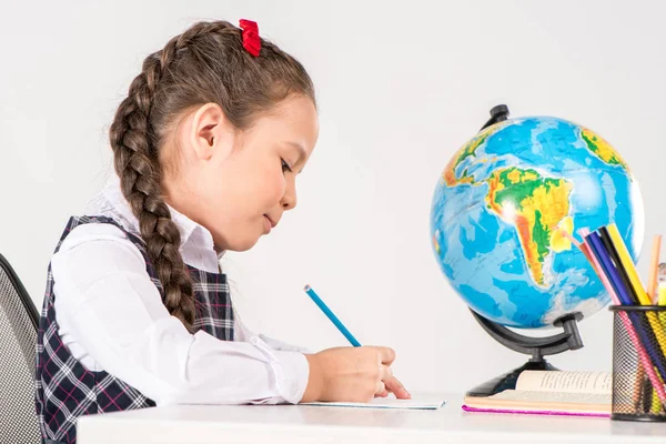 Colegiala escribiendo tarea - foto de stock