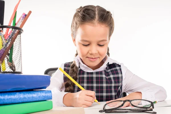 Colegiala escribiendo tarea - foto de stock