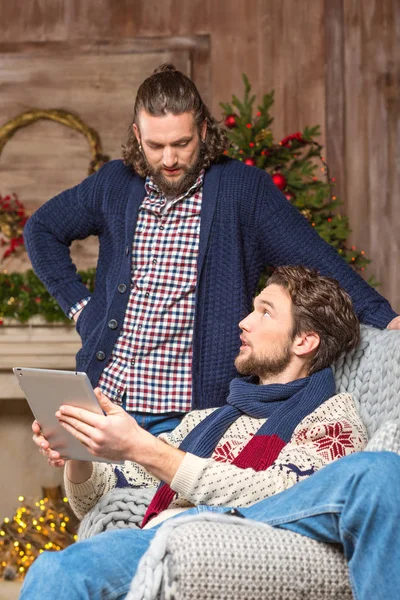 Men using tablet in cozy room — Stock Photo