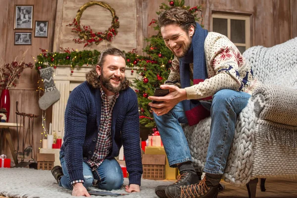 Smiling men looking at smartphone — Stock Photo