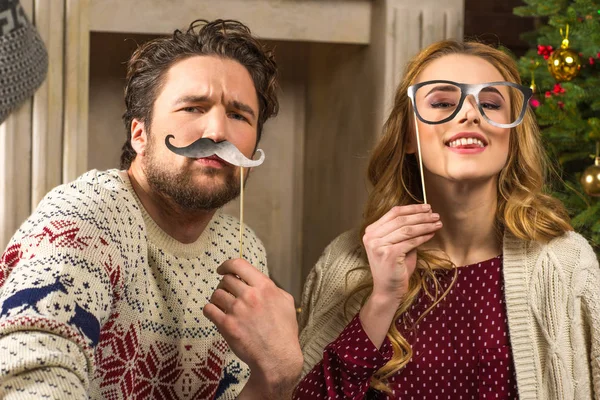 Pareja divirtiéndose con palos de fiesta — Stock Photo