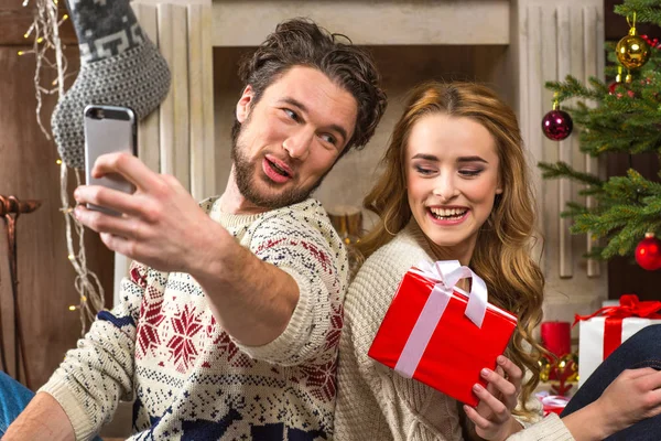 Couple taking selfie with christmas present — Stock Photo