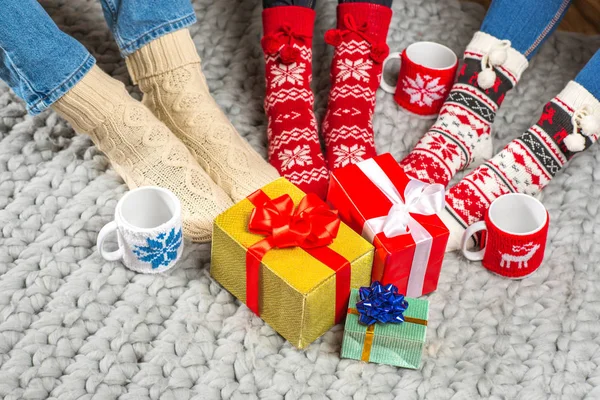 Piernas en calcetines de punto y regalos de Navidad - foto de stock