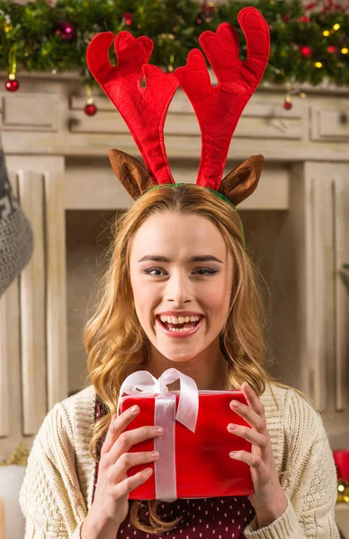 Excited woman holding christmas present — Stock Photo