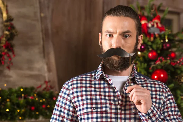 Homem sério segurando bigode de papel — Fotografia de Stock