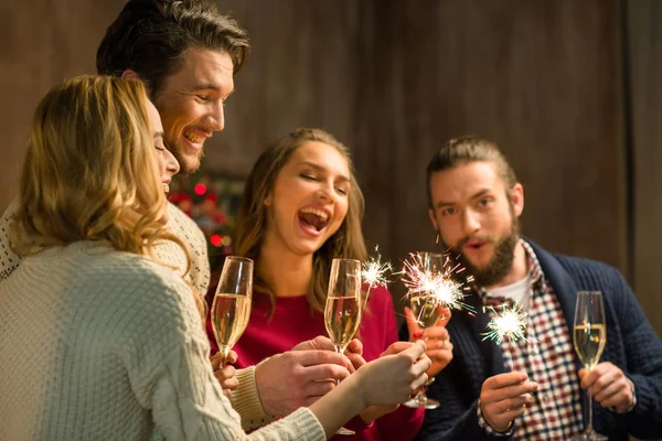 People with champagne and sparklers — Stock Photo