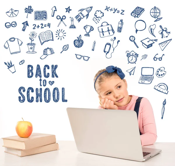 Colegiala en el escritorio con portátil — Stock Photo