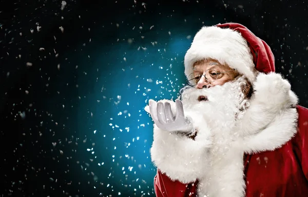 Santa Claus blåser snöflingor — Stockfoto