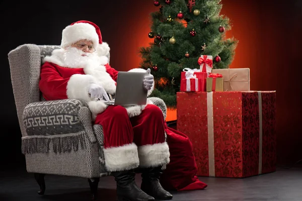 Santa claus met behulp van laptop — Stockfoto