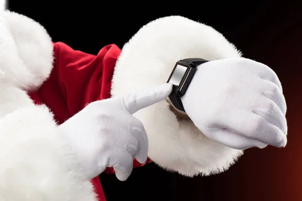 Papai Noel apontando no relógio inteligente — Fotografia de Stock