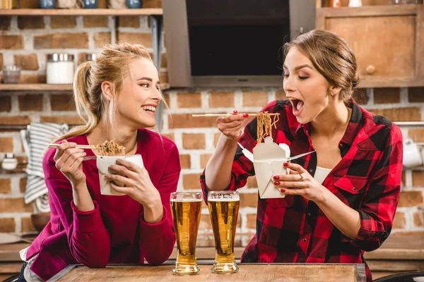 Femmes heureuses avec des nouilles et de la bière — Photo