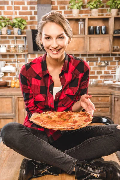 Kvinna anläggning pizza — Stockfoto