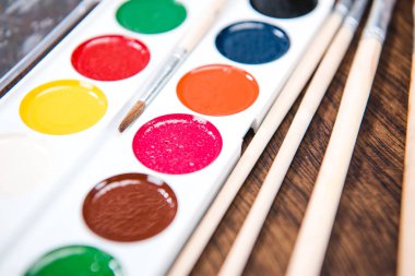 Watercolor paints and paintbrushes clipart