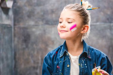 Schoolgirl artist with painted face clipart
