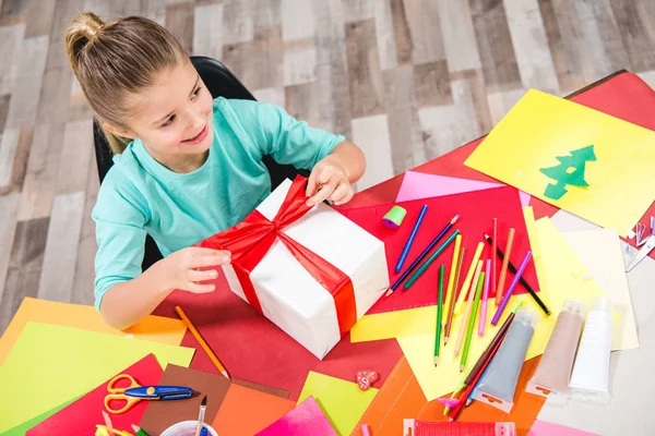 Schoolchild wrapping gift box — Stock Photo, Image