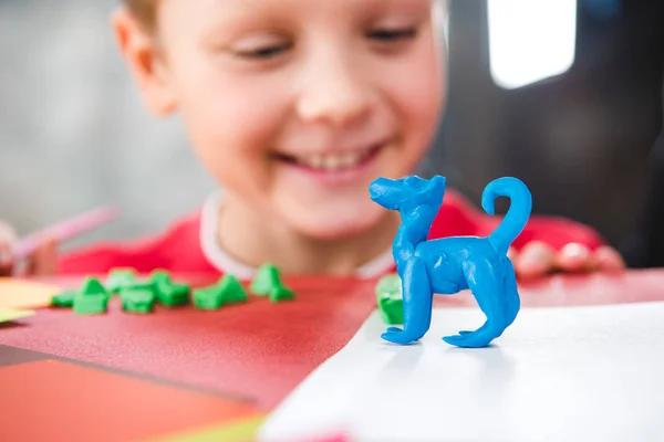 Schoolchild making toy from plasticine — Stock Photo, Image