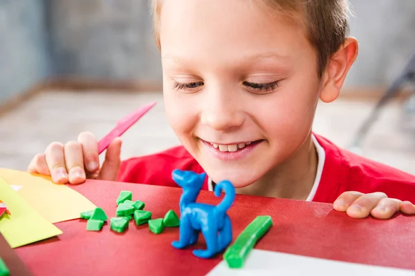 Schoolchild fazendo brinquedo de plasticina — Fotografia de Stock