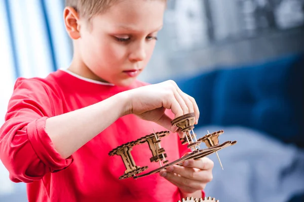Niño sosteniendo juguete de engranaje de madera —  Fotos de Stock