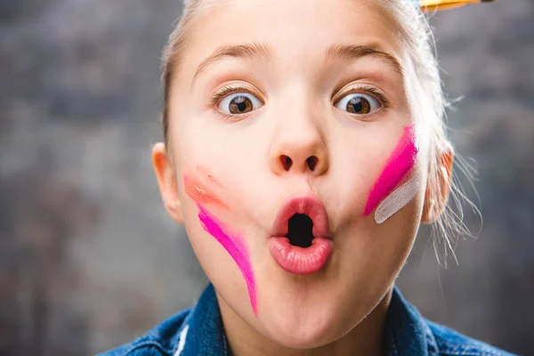 Schoolgirl artist with painted face — Stock Photo, Image