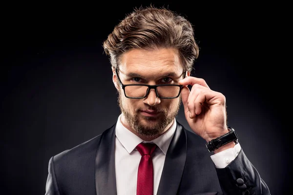 Businessman adjusting eyeglasses — Stock Photo, Image