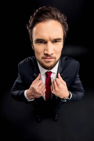 Handsome businessman adjusting jacket — Stock Photo, Image