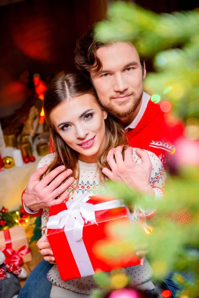 Glückliches Paar mit Weihnachtsgeschenk — kostenloses Stockfoto