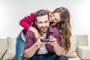 Woman hugging man playing with joystick clipart