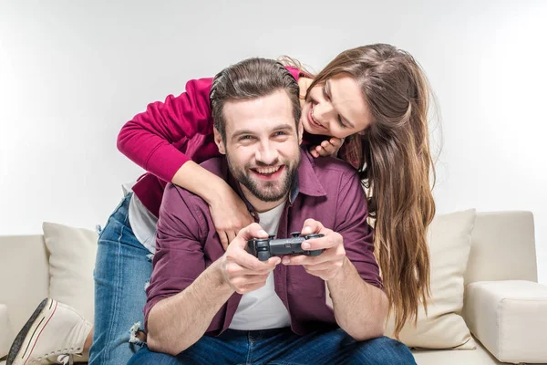 Mulher abraçando homem brincando com joystick — Fotografia de Stock