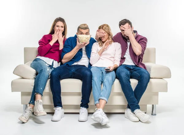 Vänner som sitter på soffan med popcorn — Stockfoto