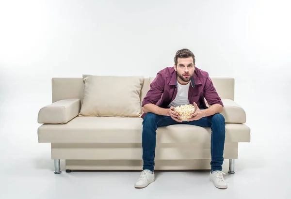 Man sitting on couch with popcorn — Stock Photo, Image