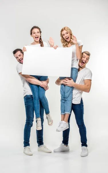 Amigos sosteniendo tarjeta en blanco — Foto de Stock