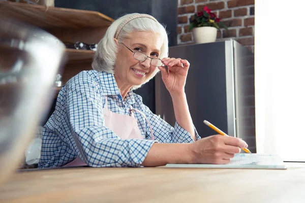 Mujer mayor con libro de cocina — Foto de Stock