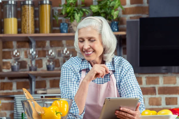 Vrouw met digitale tablet in de keuken — Stockfoto