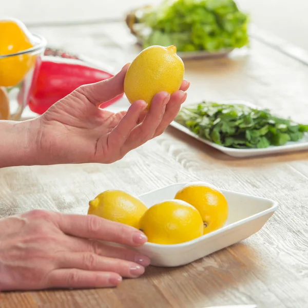 Női kezek ellenőrző citrom — Stock Fotó