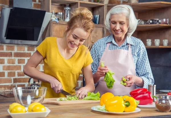 Granddaughter and grandmother cooking together — Stock Photo, Image