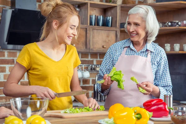 Granddaughter and grandmother cooking together — Stock Photo, Image