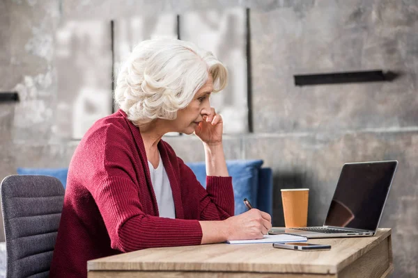 Senior vrouw maken van notities — Stockfoto