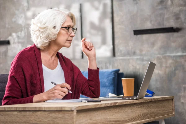 Senior woman making notes — Stock Photo, Image