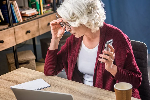 Senior woman adjusting eyeglasses — Stock Photo, Image