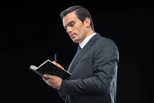 Hombre de negocios escribiendo en cuaderno — Foto de Stock