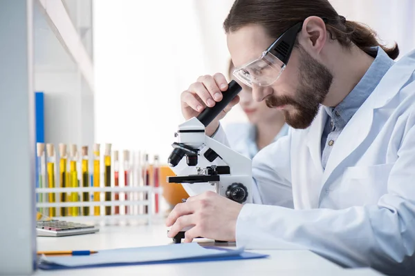 Hombre mirando en el microscopio — Foto de Stock