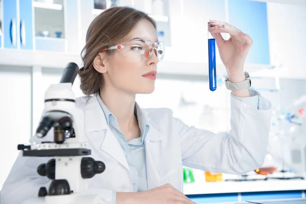 Cientista olhando no tubo de ensaio — Fotografia de Stock